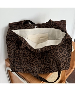 Detail of leopard print tote bag showing inner lining, zip pocket and metal snap button