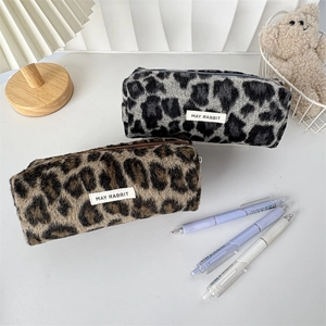 Macro view of plush leopard print pencil cases with soft faux fur and May Rabbit label