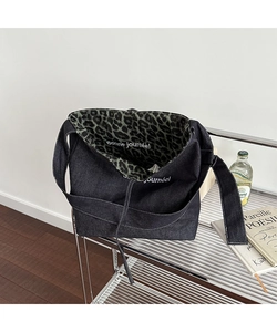 Deep blue denim tote bag with leopard print lining and white decorative interior text