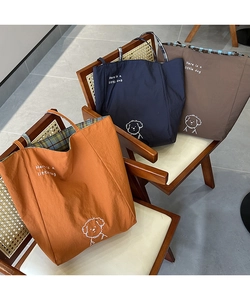 Trois sacs cabas en toile avec imprimé chien et doublure à carreaux sur une chaise
