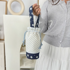 Dettaglio della borsa per borraccia con pois blu e design patchwork floreale
