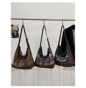 Detail of checkered canvas tote bag with letter embroidery and adjustable straps