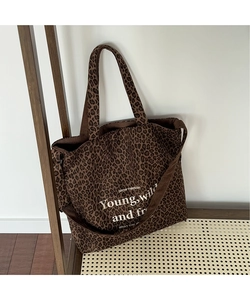 Detalle del bolso tote de pana con estampado de leopardo y texto blanco inspirador