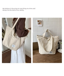Detail of minimalist beige nylon tote bag with square fabric logo patch and soft textures