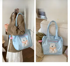 Detail of light blue tote bag featuring cute dog embroidery and pink ribbon trim