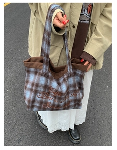 Detail of blue and brown plaid wool tote bag with brown corduroy trim and embroidery