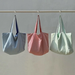 Trois sacs cabas en nylon à rayures colorées bleu, rouge et vert menthe avec poignées