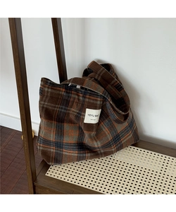 Close-up of retro brown checkered tote bag with woven texture and handmade label