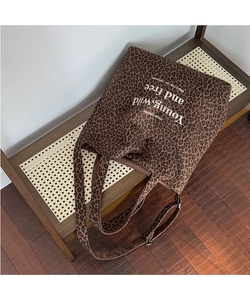 Detalle de bolso tote de leopardo con eslogan Young Wild and Free en lona