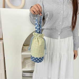 Dettaglio della borsa porta borraccia con patchwork a quadri gialli e pois blu e lacci