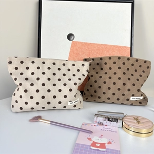 Detailed view of polka dot corduroy cosmetic bags with MAY RABBIT label and makeup items