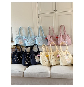 Detail of cute embroidered puppy tote bags with drawstring closure in various colors
