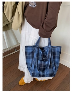 Close-up of blue plaid nylon tote bag featuring spacious design and comfortable shoulder strap