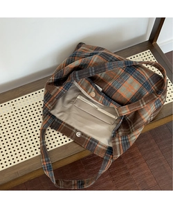 Detail of checkered tote bag interior with magnetic closure and beige lining