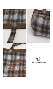Detailed close-up of corduroy plaid tote featuring vintage embroidery and stitched handle