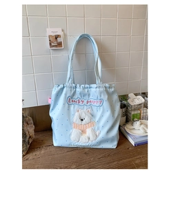 Close-up of cute cartoon puppy embroidery on light blue polka dot drawstring tote bag