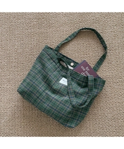 Close-up of green and blue checkered tote bag with metal magnetic snap button closure