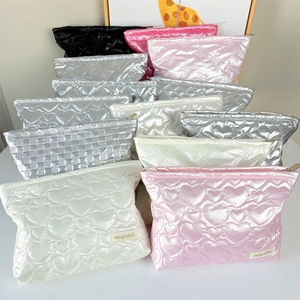 Detailed shot of quilted PU makeup bags featuring heart and bow patterns in satin finish