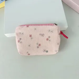 Vue détaillée de la pochette en velours côtelé rose fleuri sur un livre rétro