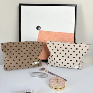 Detail of vintage polka dot corduroy cosmetic bags with zipper closure and logo patch