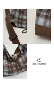 Close-up of brown corduroy and plaid wool texture with embroidery on a tote bag