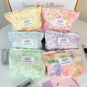 Detailed set of six colorful plush floral cosmetic bags with zip closure and white labels