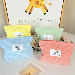 Detail of waffle-textured makeup bags in lemon, mint, blue, and coral pink colors