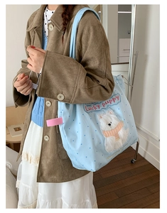 Detail of light blue polka dot tote bag with cute Lucky Puppy embroidery and pink trim