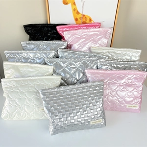 Detailed close-up of quilted cosmetic bags in silver, pink, and black colors