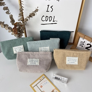 Detailed view of corduroy cosmetic bags in five soft colors with zipper and woven labels
