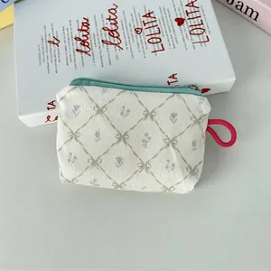 Détail de la trousse à maquillage en velours côtelé fleuri avec cordon rose vif