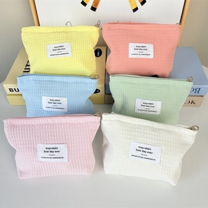 Collection of waffle weave makeup bags in pastel colors with premium metal zippers