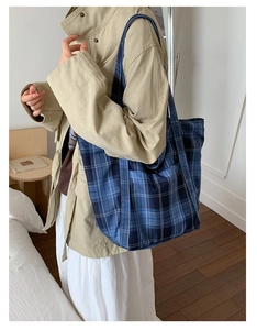 Close-up of blue checkered nylon tote bag with wide shoulder strap for commuting