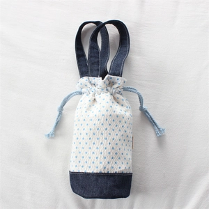 Dettaglio della borsa portabottiglie con pois blu e patchwork denim sul fondo borsa