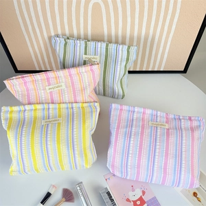 Striped seersucker cosmetic bags in four pastel colors with metal zippers for travel storage