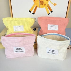 Pastel waffle weave cosmetic bags in yellow, pink and beige with zipper closure