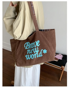 Brown corduroy tote bag detail with blue embroidery and vintage check lining on shoulder