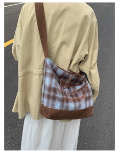 Detail of checkered canvas tote bag with coffee embroidery and corduroy strap on model