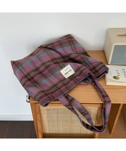 Detail of checkered tote bag with woven purple pattern and handmade fabric label