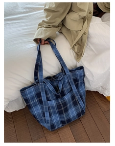 Close-up of blue plaid nylon tote bag with functional front pocket for daily commute