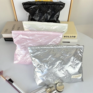 Close-up of quilted bow pattern on waterproof makeup bags in four assorted colors