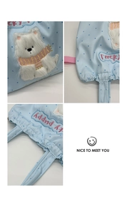 Detail of cute plush puppy embroidery and Lucky Puppy lettering on light blue polka dot bag