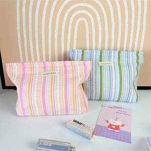 Detail of colorful striped cosmetic bags with textured fabric and zipper closure
