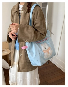 Close-up of blue polka dot canvas tote bag with 3D cute puppy embroidery and red text