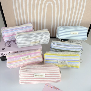 Macro view of textured pleated cotton pencil cases with stripes and zip closure