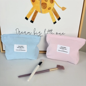 Close-up of soft waffle fabric makeup bags in blue and pink with zipper closure