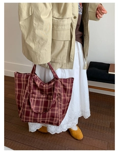 Detail of burgundy checkered nylon tote bag with front pocket and sturdy double handles
