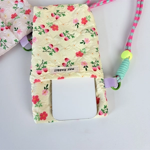 Detail of quilted phone bag featuring pink floral strawberry prints and adjustable strap