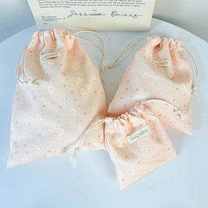 Detailed set of three pink corduroy drawstring storage bags with cute rabbit prints