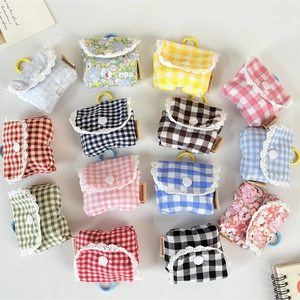 Flat lay of diverse floral and plaid pattern mini earphone pouches with lace trim